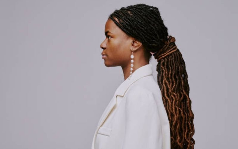 Black woman with curly ponytail highlighting natural volume