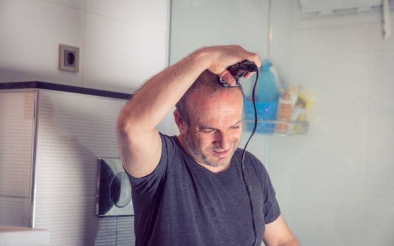 Shaving the head carefully with controlled strokes to avoid cuts