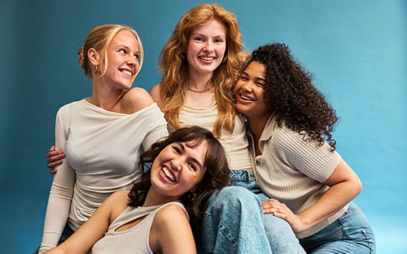 four women showing straight, wavy, curly, and coily hair