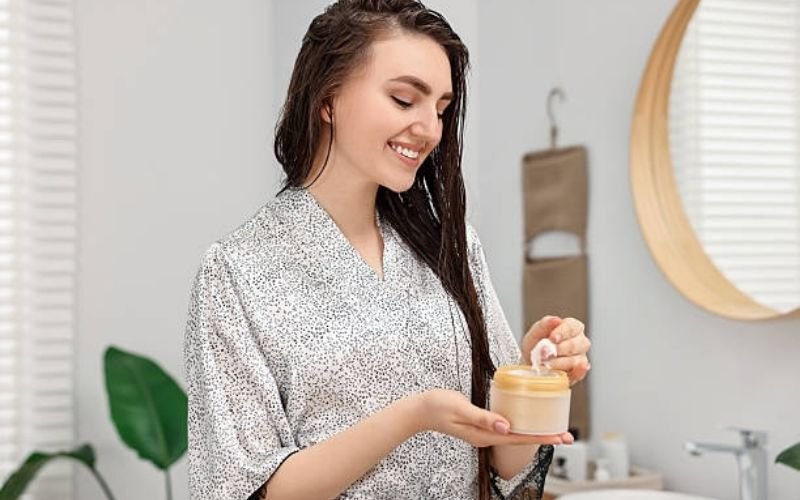 woman applying hair mask for damaged hair.