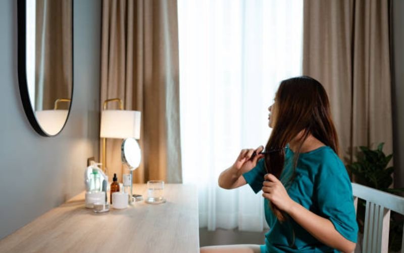 Woman maintaining her natural hair care routine with natural products at home