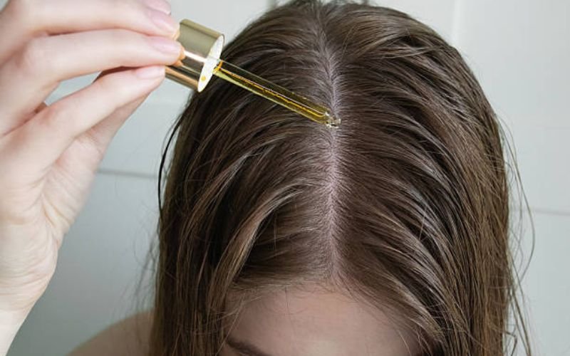 Applying natural oils to scalp for hair growth and strengthening natural hair.