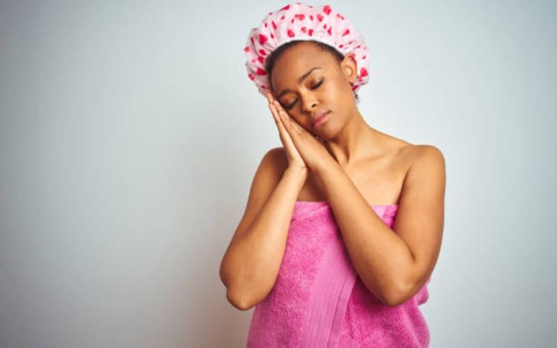 woman wearing satin bonnet sleeping, hair moisturized and protected